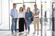 © opolja - Young modern colleagues in smart casual wear looking at camera standing in the creative office.