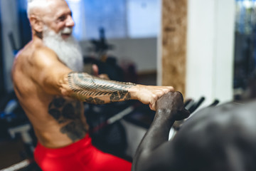 Athletes with different age and race doing bike exercises in gym - Fit people training on cycling machine in health wellness center - Sport activity and fitness lifestyle concept