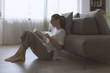 © stokkete - Happy woman sitting on the floor and reading a book