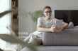 © stokkete - Woman relaxing on the sofa and connecting with her touch screen tablet