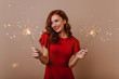 © Look! - Blissful curly woman with sparklers enjoying christmas time. Indoor photo of laughing pretty girl with bengal lights.