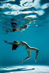 Wall Mural - A woman with nice body dancing under water.Underwater photo