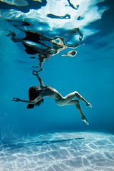 Wall Mural - A woman with nice body dancing under water.Underwater photo