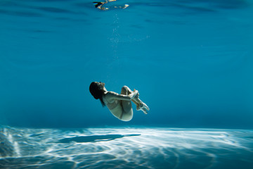 Wall Mural - A woman with nice body dancing under water.Underwater photo