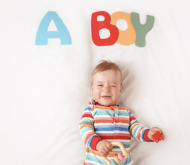 Wall Mural - Baby boy lying on the blanket with letters above