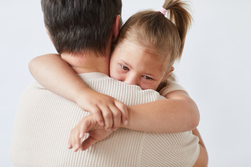 Little girl embracing and loving her father against the white background