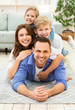 © Prostock-studio - Positive Family Of Four Lying Posing On Floor Indoors