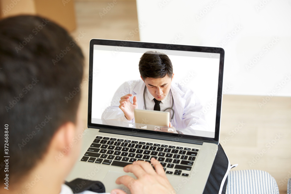young asian man receiving a diagnosis using telehealth network - obrazy, fototapety, plakaty 