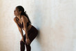 © Drobot Dean - Photo of african american woman leaning on wall while working out
