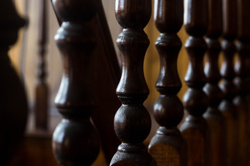 Wall Mural - The dark brown wooden railing is carved into the distance. The railing of the stairs