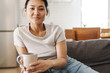 © Drobot Dean - Smiling attractive young woman sitting on the couch