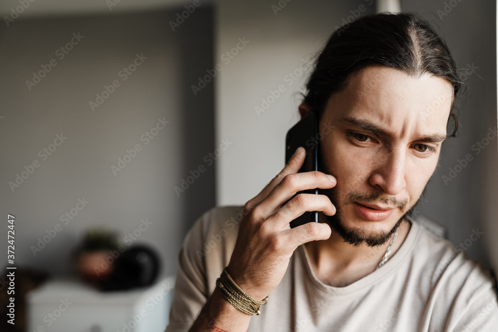 Close up of a concerned mman talking on mobile phone
