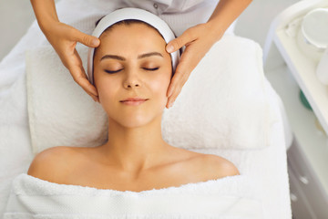 Wall Mural - Female face massage in a beauty salon. Beautician makes facial skin treatment in a beauty clinic