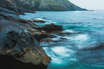 Rocky sea shore, cliffs with surf on the Gamova Peninsula in the Primorsky territory, seascape of Russia.