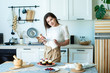© Svetlana - pretty housewife smiles and prepares muffins with colored berries. garnishes with raspberries and blueberries. Lifestyle