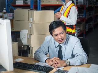 Stressed warehouse manager worries about financial balance trouble of his company at his office in the warehouse. Business industry fails or closes due to COVID-19 or coronavirus disease impact...