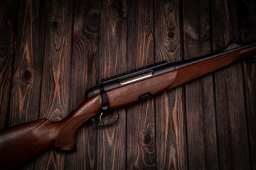 Poster - Rifle with a wooden stock on a dark back. Weapons for sports, hunting and self-defense.