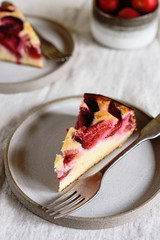 Wall Mural - Slices of Homemade Ricotta Plum Cake on plates on beige linen tablecloth. Cottage cheese casserole with vanilla, semolina and plums. Selective focus