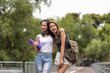 © surachetkhamsuk - Two happy Asian students talking while walking in campus