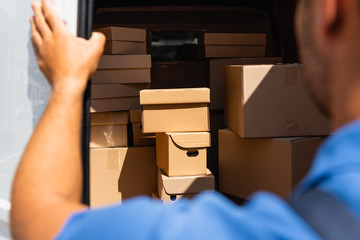 Wall Mural - Cropped view of loader standing near cardboard boxes in truck outdoors