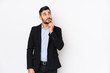 Young caucasian business man against a white background isolated looking sideways with doubtful and skeptical expression.