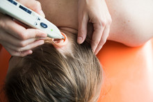 Physiotherapist Using Stimulator Of Acupuncture Points On Ear Of Female Patient