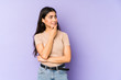 © Asier - Young indian woman isolated on purple background touching back of head, thinking and making a choice.
