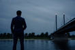 © Joseffson/Westend61 - Mature businessman standing at the riverbank at dusk