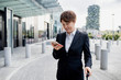 © Eugenio Marongiu/Westend61 - Female entrepreneur with short hair using mobile phone while standing on sidewalk in city