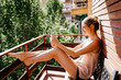 © Tania Cervián/Westend61 - Young woman making video call while sitting on chair in balcony at home