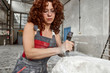 © victor espadas gonzalez/Westend61 - Close-up of woman with curly hair carving stone in workshop