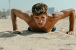 © VALENTINA BARRETO STUDII/Westend61 - Shirtless young man doing push-ups on sand at beach during sunny day