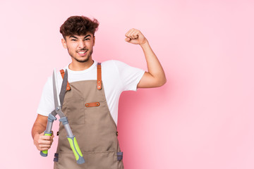 Young arab gardener man isolated raising fist after a victory, winner concept.