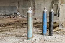 Metallic Oxygen Gas Cylinders On Abandoned Industrial Area. Reconstruction Work.
