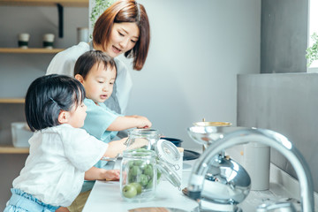 キッチンでお母さんが子供二人に料理を教えている　mother kids 子育て