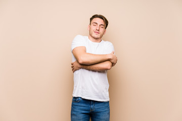 Wall Mural - Young caucasian man posing isolated hugs, smiling carefree and happy.