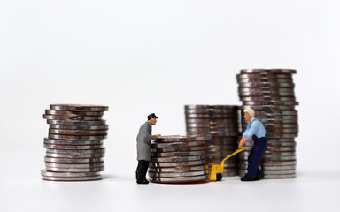 Miniature people carrying a pile of coins. 
