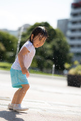 Wall Mural - 広場の噴水で水遊びする子供