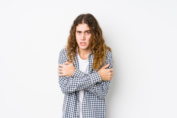 Wall Mural - Young long hair man posing isolated going cold due to low temperature or a sickness.