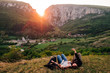 © Jake Jakab/ADDICTIVE STOCK - Group of friendly people relaxing on lawn in highlands at sunset and taking selfie on smartphone during vacation in Transylvania
