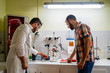 © Javier De La Torre/ADDICTIVE STOCK - Side view of bearded chemist in eyeglasses standing near coworker in casual clothes in front of wine analysis equipment and flasks in lab