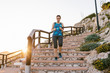 © Lightsy/ADDICTIVE STOCK - Low angle of sportswoman in t shirt and leggings running down stone steps while training during sunset