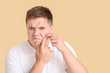 © Pixel-Shot - Teenage boy with acne squishing pimples on color background