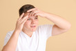 © Pixel-Shot - Teenage boy with acne squishing pimples on color background