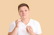 © Pixel-Shot - Teenage boy with remedy for acne on color background