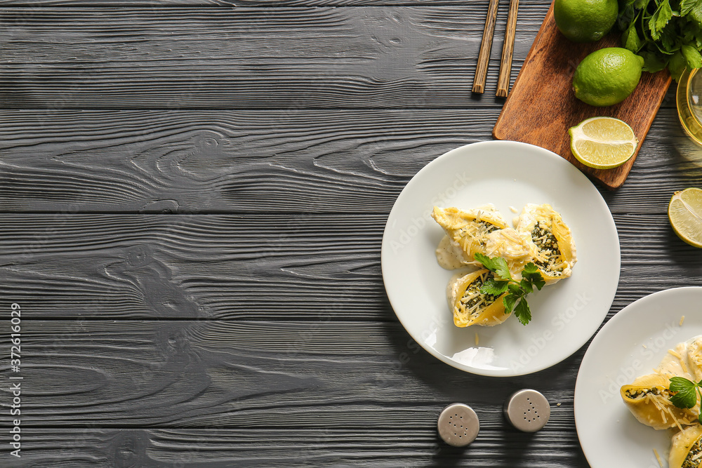 Plate with tasty conchiglioni pasta on table