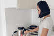 © Sevendeman - Asian woman is cooking simple breakfast in white cozy kitchen.