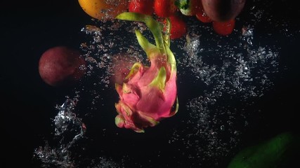 Wall Mural - Shooting of falling exotic fruits in the water on black background