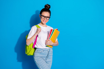 Poster - Portrait of her she nice attractive pretty lovely cheerful cheery girl diligent nerd going back to school carrying subject exercise book isolated bright vivid sine vibrant blue color background