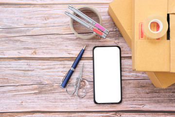 Poster - Delivery box on wood table background. Online selling 
concept